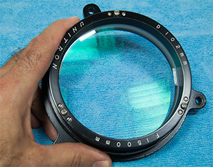 telescope objective lens, after cleaning and illuminated to demonstrated the green multilayer antireflection coatings (82,557 bytes)